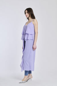 Top in lilla con un taglio aderente, che sottolinea la forma della donna in modo seducente.