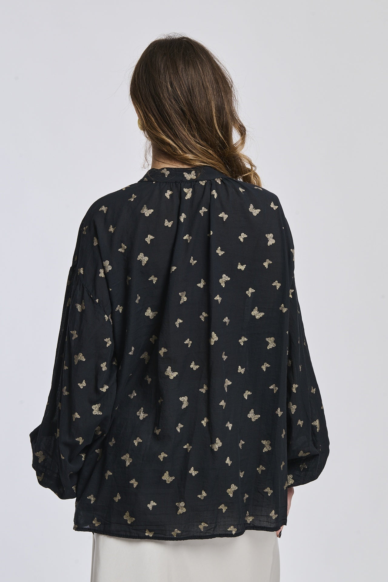 Camicia nera con motivi contrastanti, taglio oversize, maniche ampie, perfetta per un look notturno e drammatico.