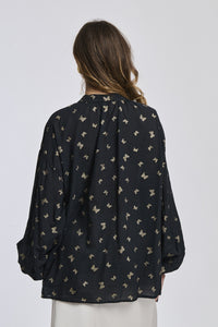 Camicia nera con motivi contrastanti, taglio oversize, maniche ampie, perfetta per un look notturno e drammatico.