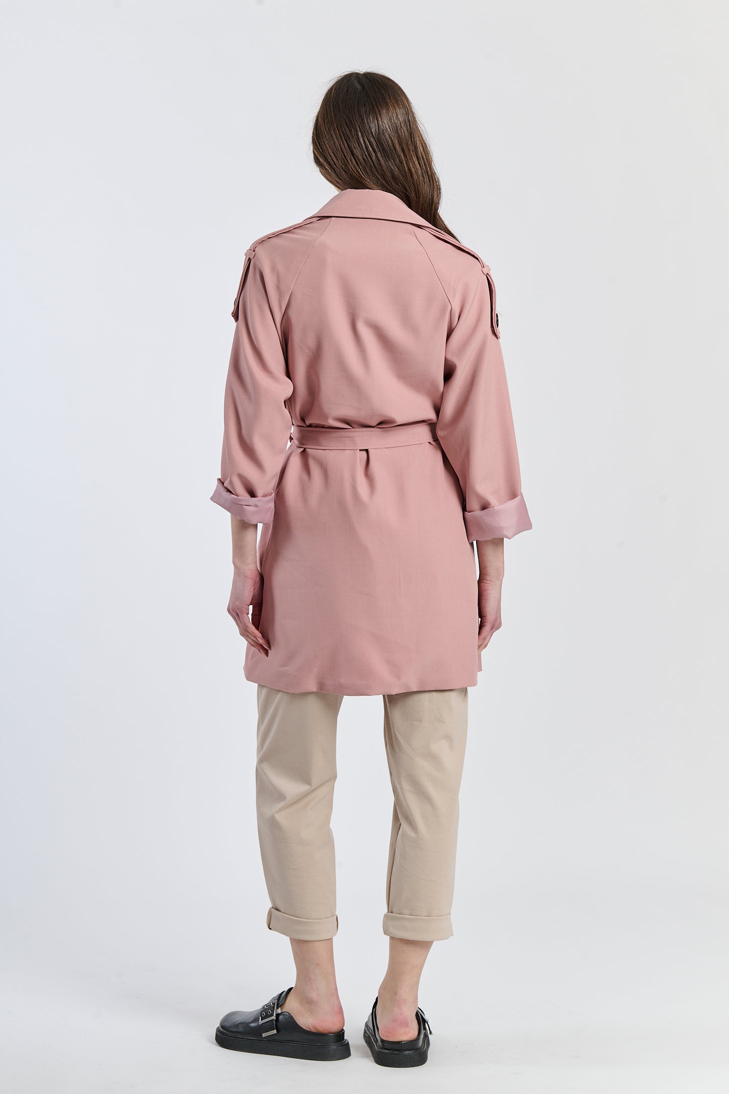 Trench rosa antico pastello, stile vintage per un’atmosfera dolce.