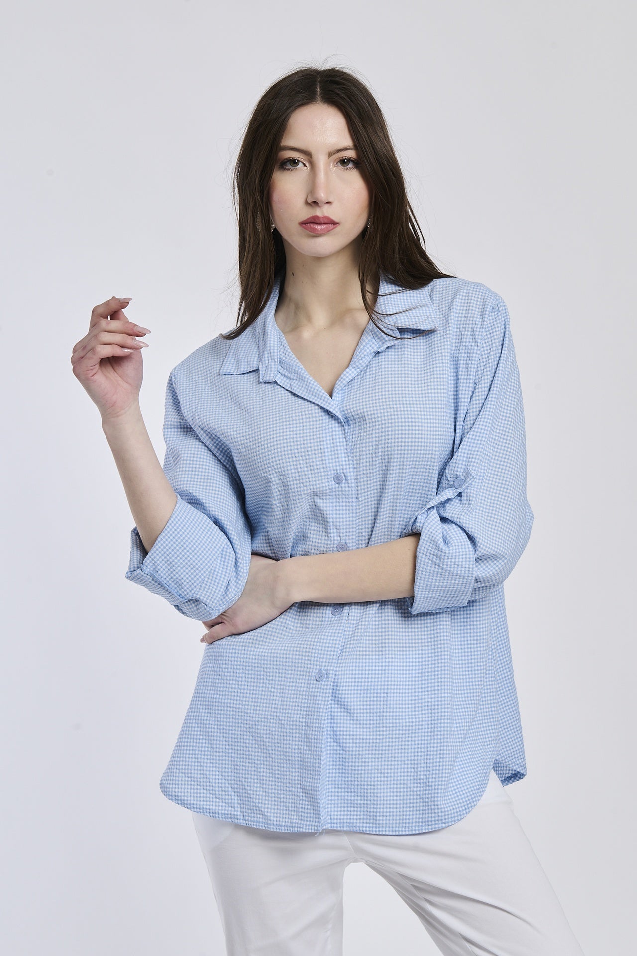 Camicia azzurra a righe, collo camiciera, maniche a 3/4, abbinata a pantaloni chiari.
