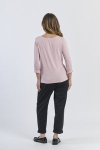 Blusa rosa antico a maniche 3/4, abbinata a pantaloni neri, contrasto accattivante