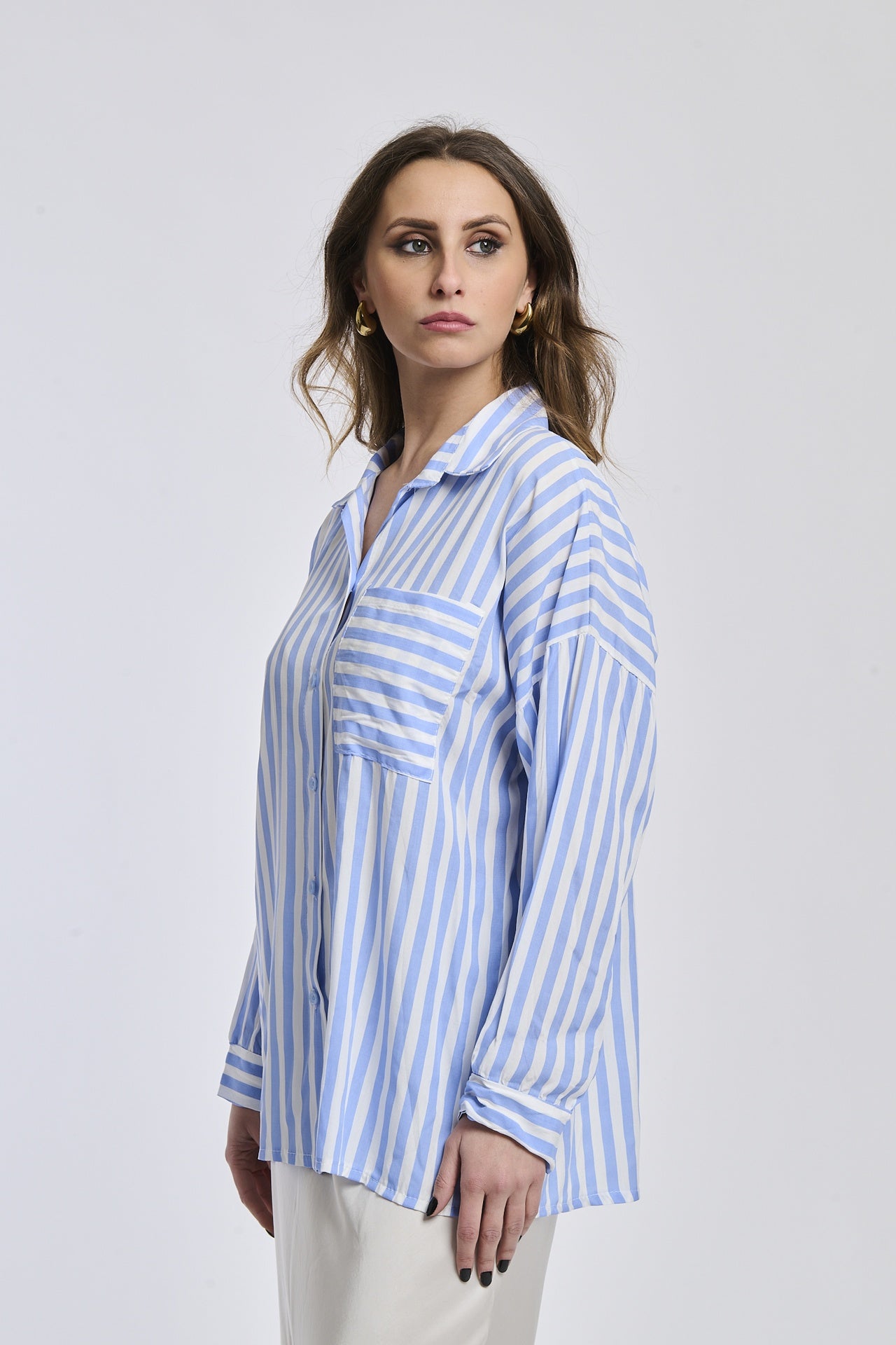 Camicia a righe azzurre e bianche da donna, taglio oversize, perfetta per un look rilassato e cool.