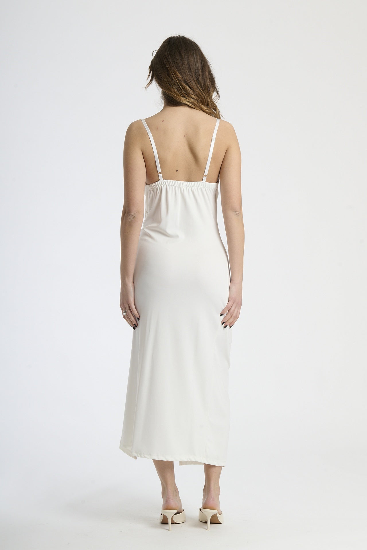 Vestito bianco in tessuto luminoso, design con ruches e spalanca, perfetto per matrimoni e eventi estivi.