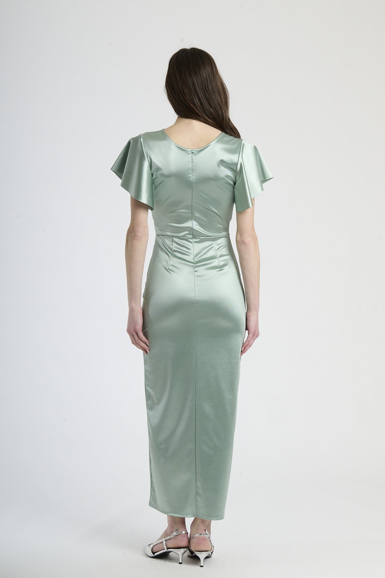 Modella in abito salvia a scollatura V, stile delicato per eventi all’aperto.