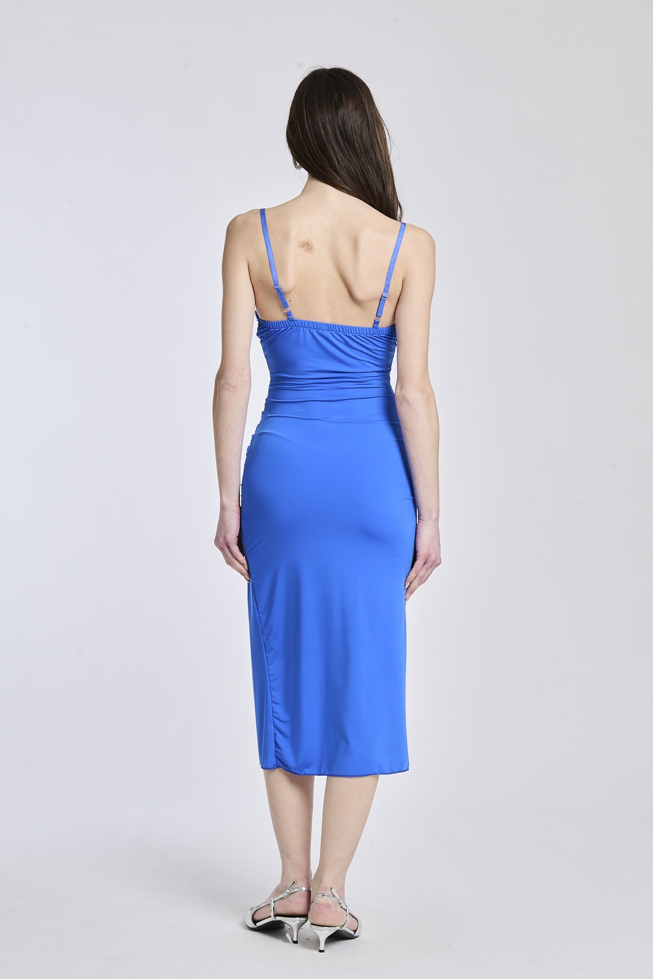 Abito bluette a spalline sottili, tessuto fluido e apertura laterale per un’eleganza minimalista.