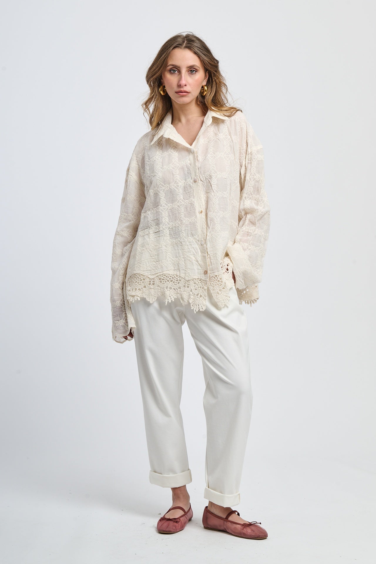 Outfit con maglia rosa scura a colletto alto e pantaloni grigi chiari, stile moderno e elegante.