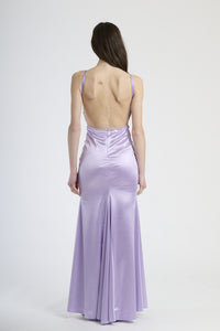 Abito lilla in raso con taglio aderente, abbigliamento dal tocco surreale e lussuoso.