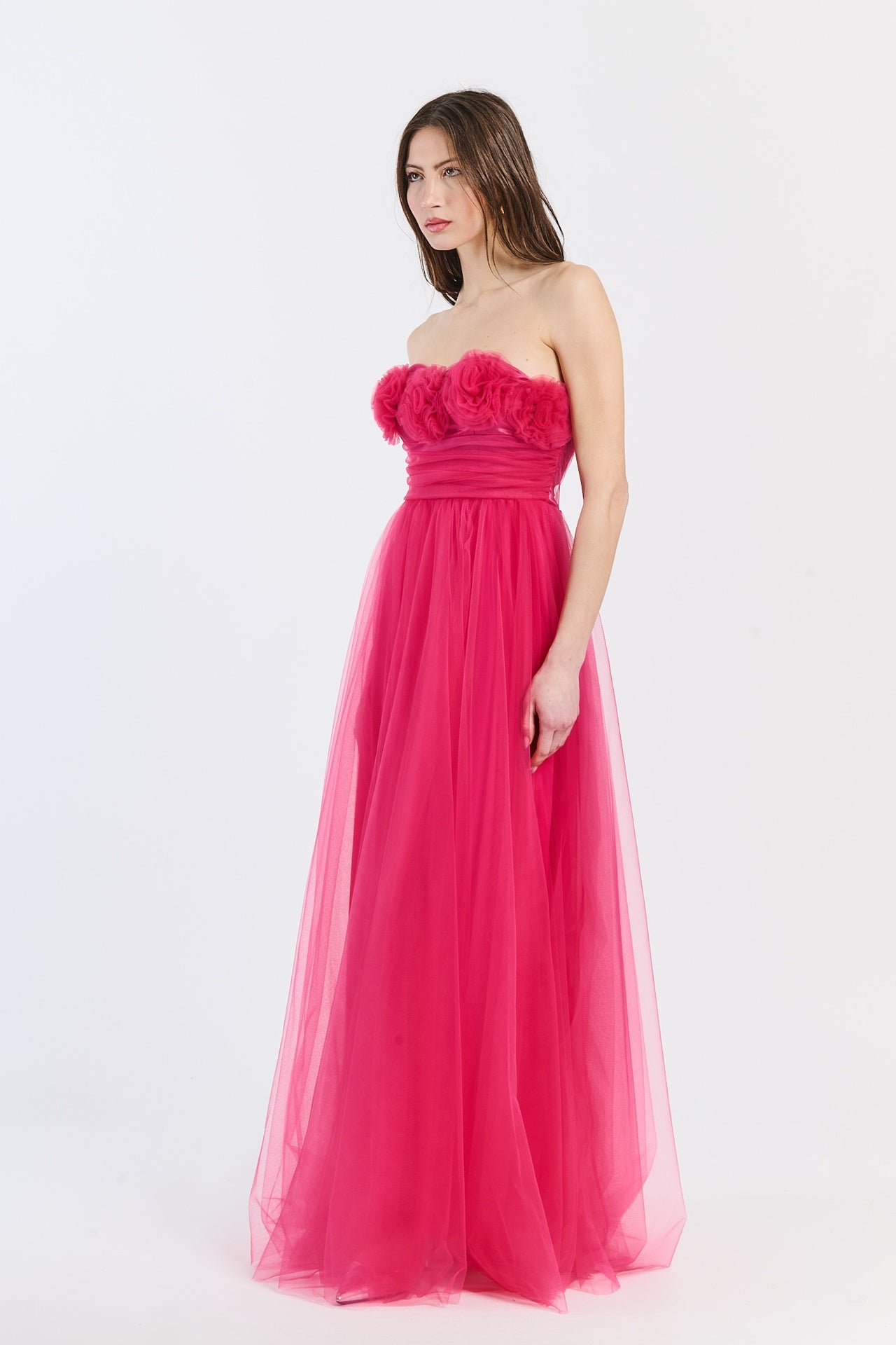 Abito formale fuxia con tulle drammatico, scollo a barca e silhouette iconica, adatto per serate all’aperto e trendy