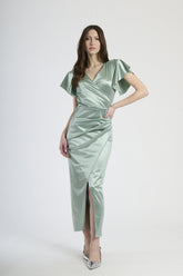 Donna con abito salvia in velluto, tranquillità naturale ed eleganza rinfrescante.