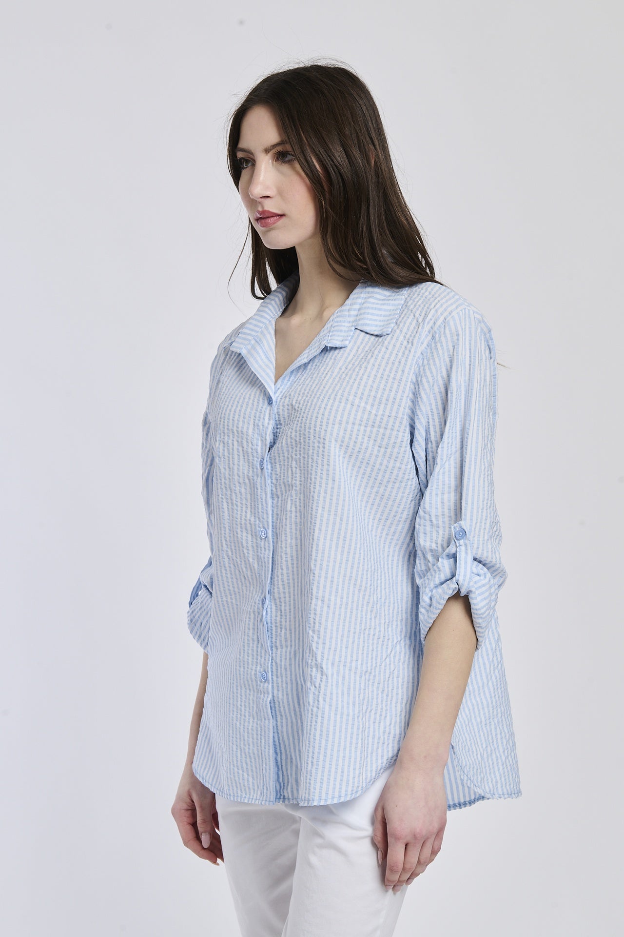 Camicia a righe azzurre, taglio ampio, colletto a camicia, bottoni e maniche arrotolate, perfetta per un look rilassato.