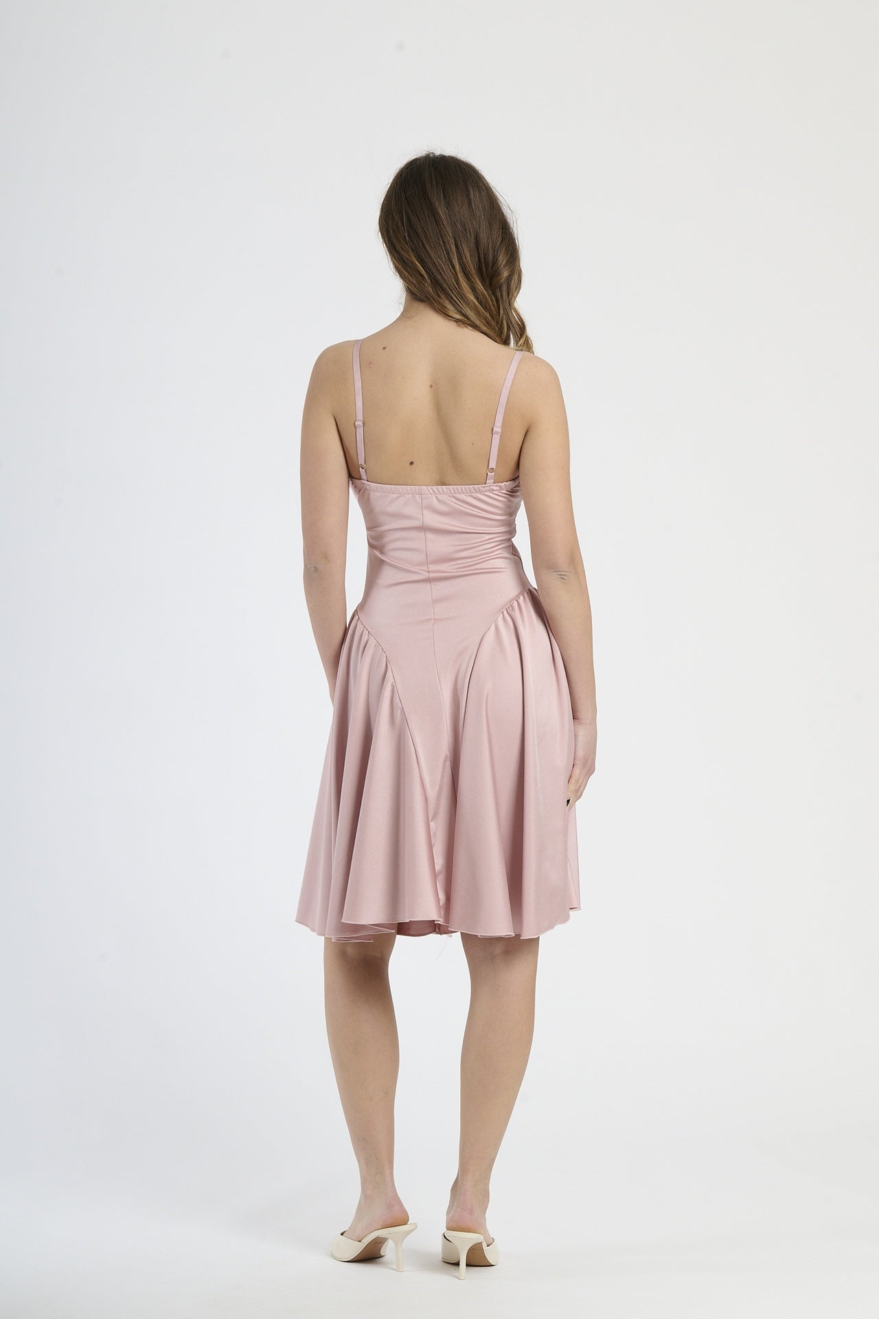 Modella indossa abito rosa antico, stile delicato e nostalgico.