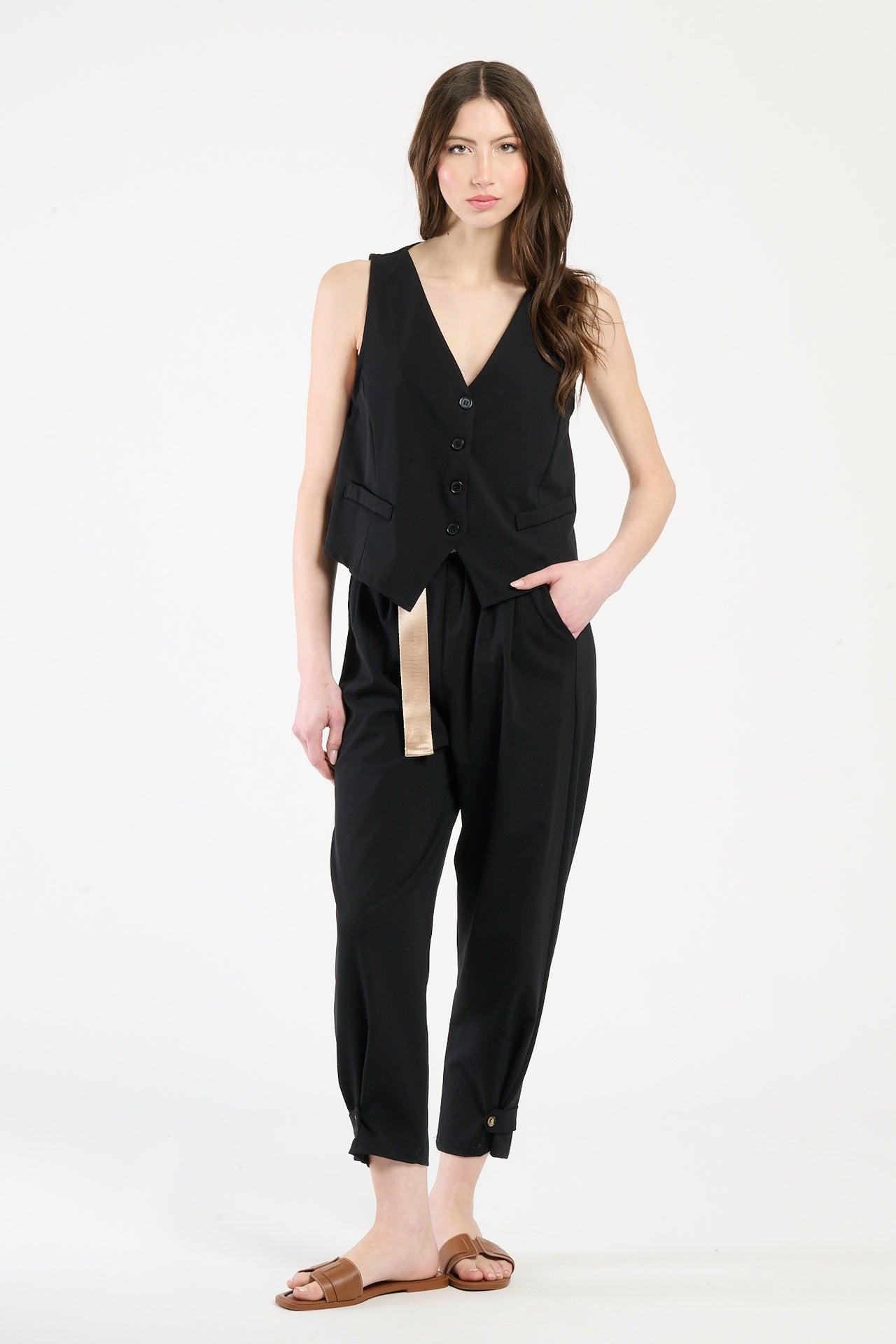 Completo nero su una modella: gilet a bottoni e pantaloni