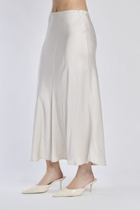 Gonna beige in raso lucido, vista frontale con scarpe alti tacchi