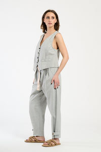 Modella indossa completo grigio: gilet senza maniche e pantaloni,