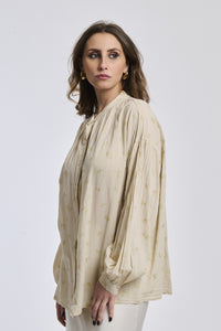 Camicia beige con motivi delicati, taglio oversize, maniche ampie, perfetta per un look estivo e naturale.