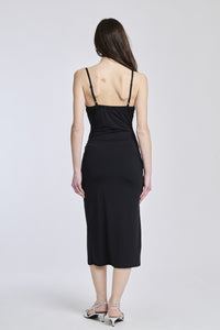 Abito nero a spalline sottili, tessuto lucido e apertura laterale per uno stile sexy e elegante.