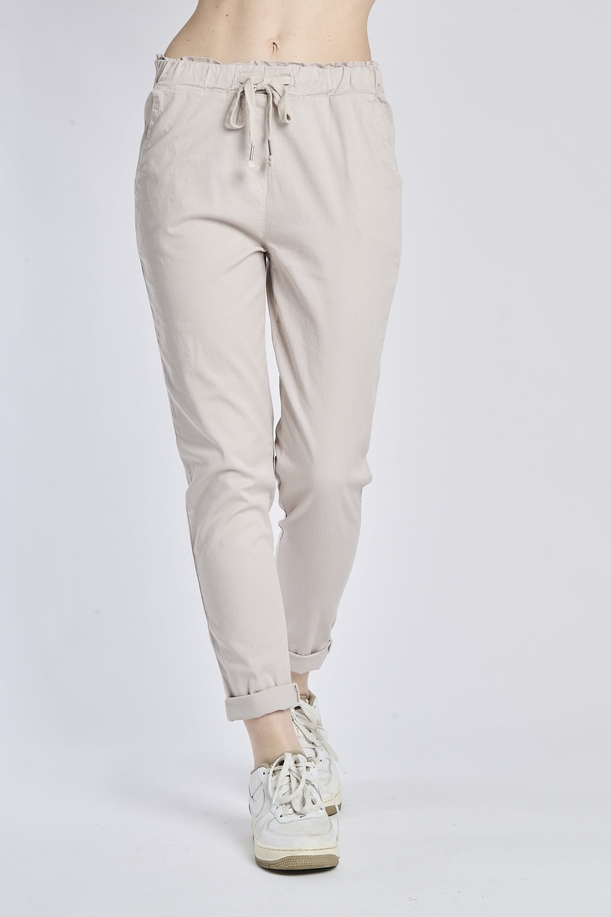 Pantaloni jogger beige con coulisse, stile casual e comodo, abbinati a sneaker bianche