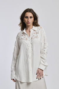 Una donna veste una camicia di un colore blu oscuro, la quale sottolinea la sua personalità profonda e riflessiva.