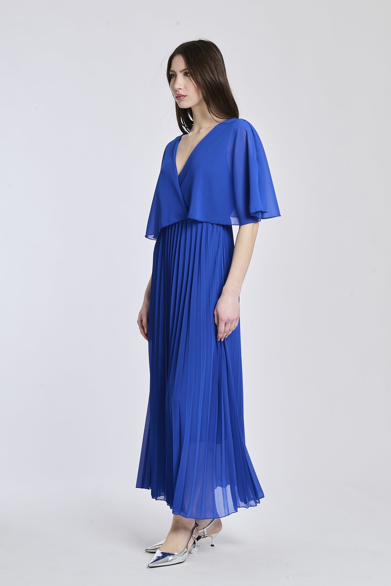 Vestito in tono bluette chiaro con dettagli di falde e maniche, offrendo un look moderno e accattivante.