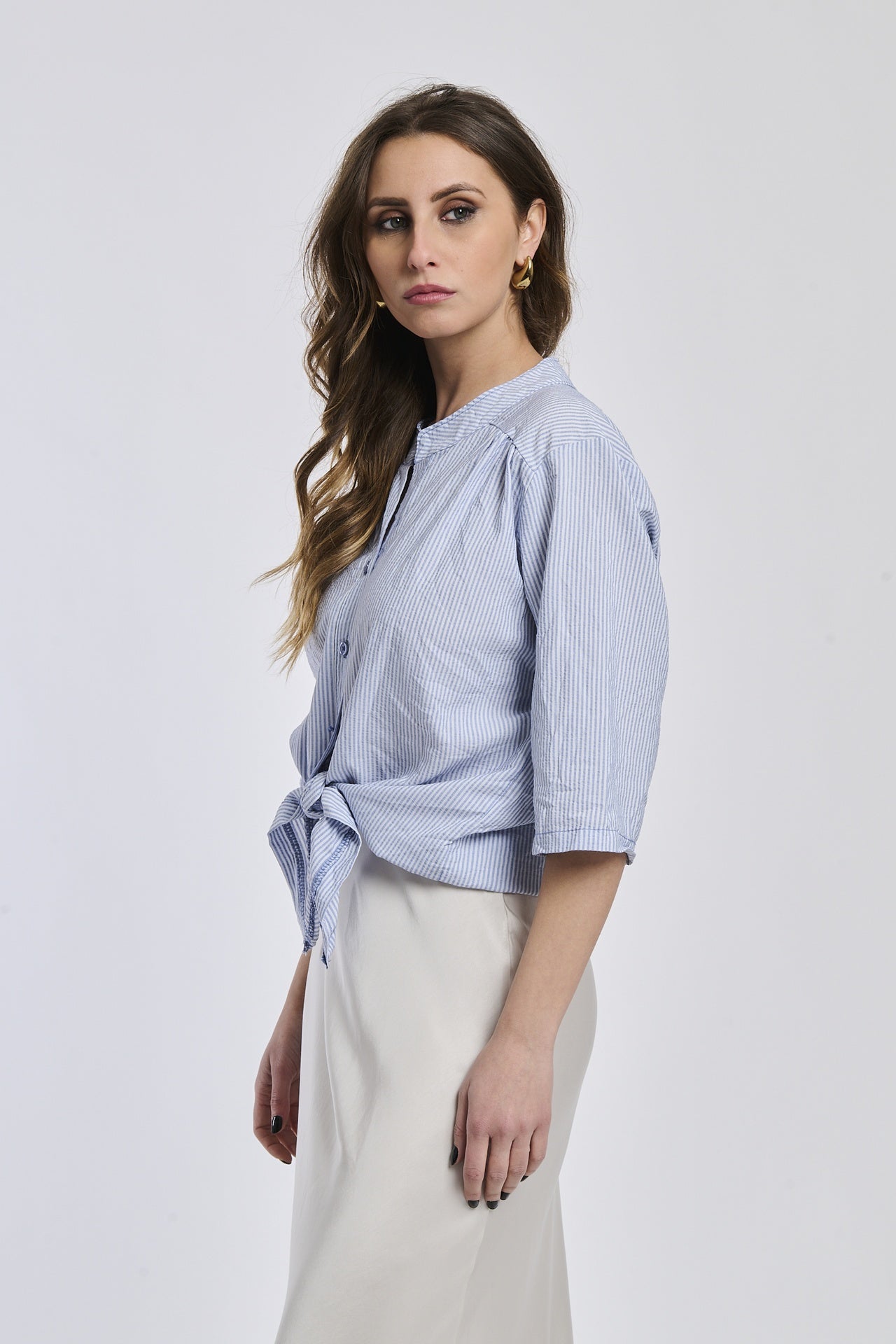 Camicia a righe navy da donna, realizzata in un tessuto leggero con nodo frontale, perfetta per le giornate di primavera.