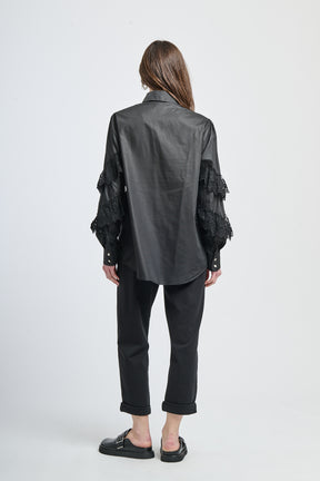 Camicia elegante in tessuto nero con incastonature di pizzo e decorazioni a chiodini.