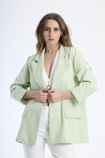 Donna con blazer verde menta, freschezza e modernità stilistica.