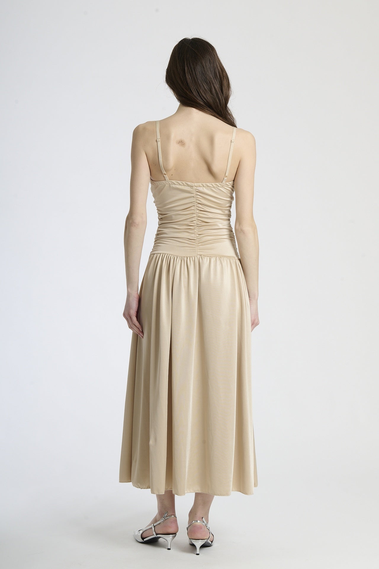 Vestito beige in tessuto morbido, taglio maxi con scollatura a V, adatto per occasioni sofisticate.