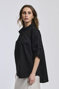 Camicia nera oversize, colletto alto, maniche arrotolate, stile cool e moderno.