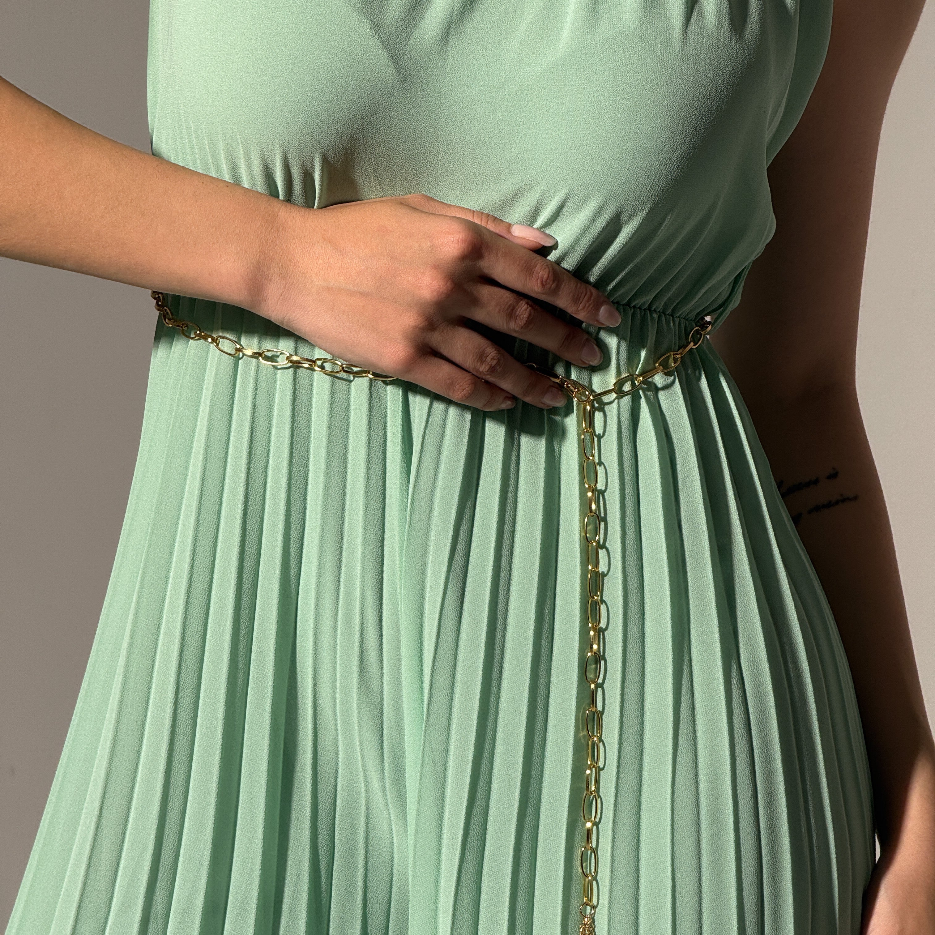 Jumpsuit verde menta con colletto a scollo alto, stile minimale ed elegante.