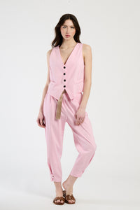 Donna con completo rosa: gilet e pantaloni, dolcezza e vivacità in un unico look.