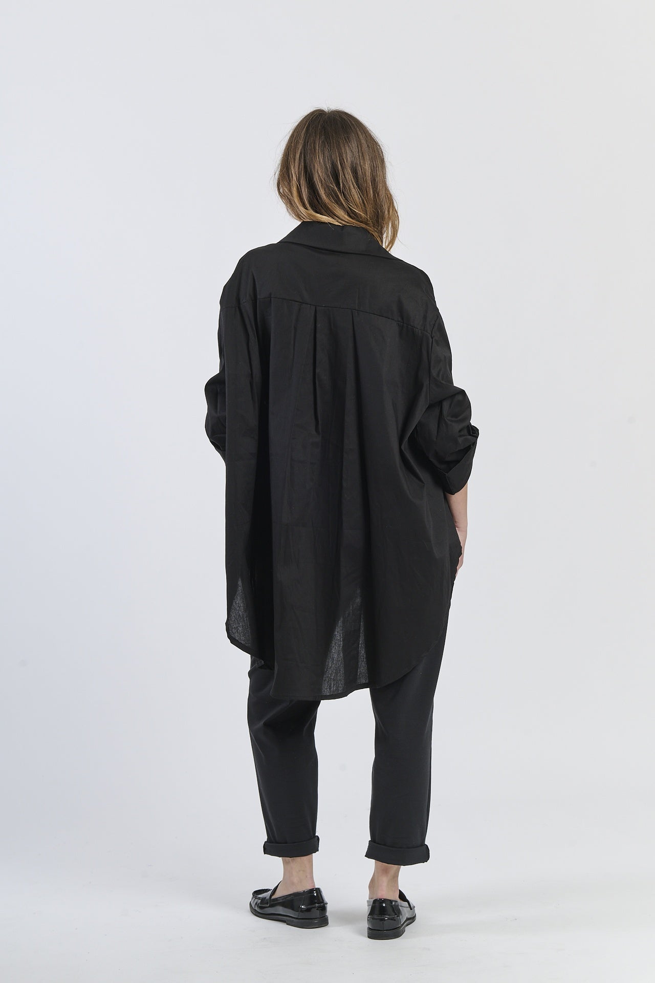 Camicia nera a maniche arrotolate, look classico e moderno