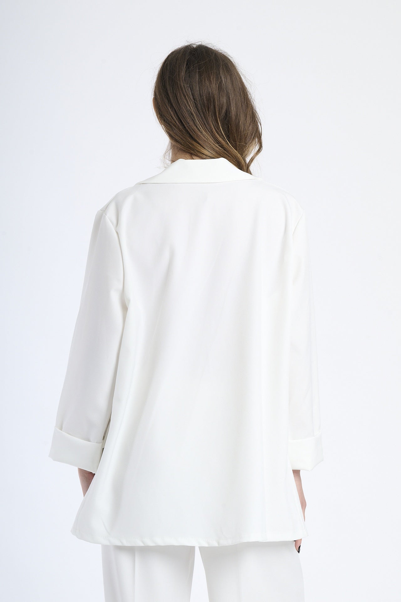 Modella indossa blazer bianco, stile pulito e raffinato.