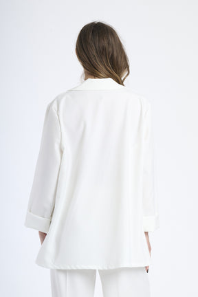 Modella indossa blazer bianco, stile pulito e raffinato.