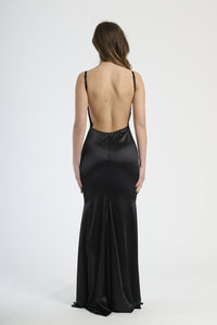 Modella indossa abito nero a spalline sottili, stile classico e glamour per serate formali.