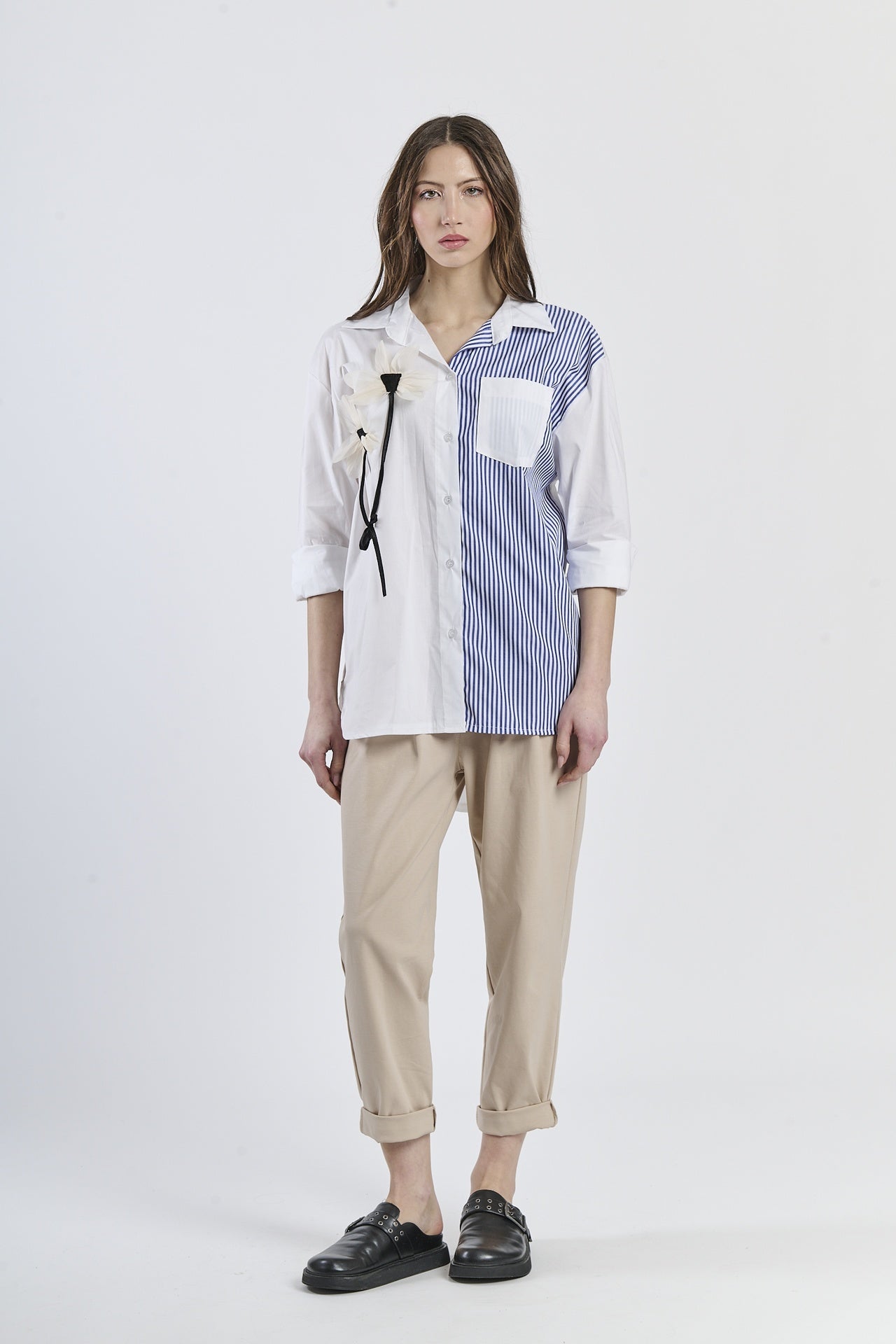 Look fashion con camicia navy a righe, colletto classico, maniche a 3/4 e decorazione floreale, abbinata a pantaloni scuri