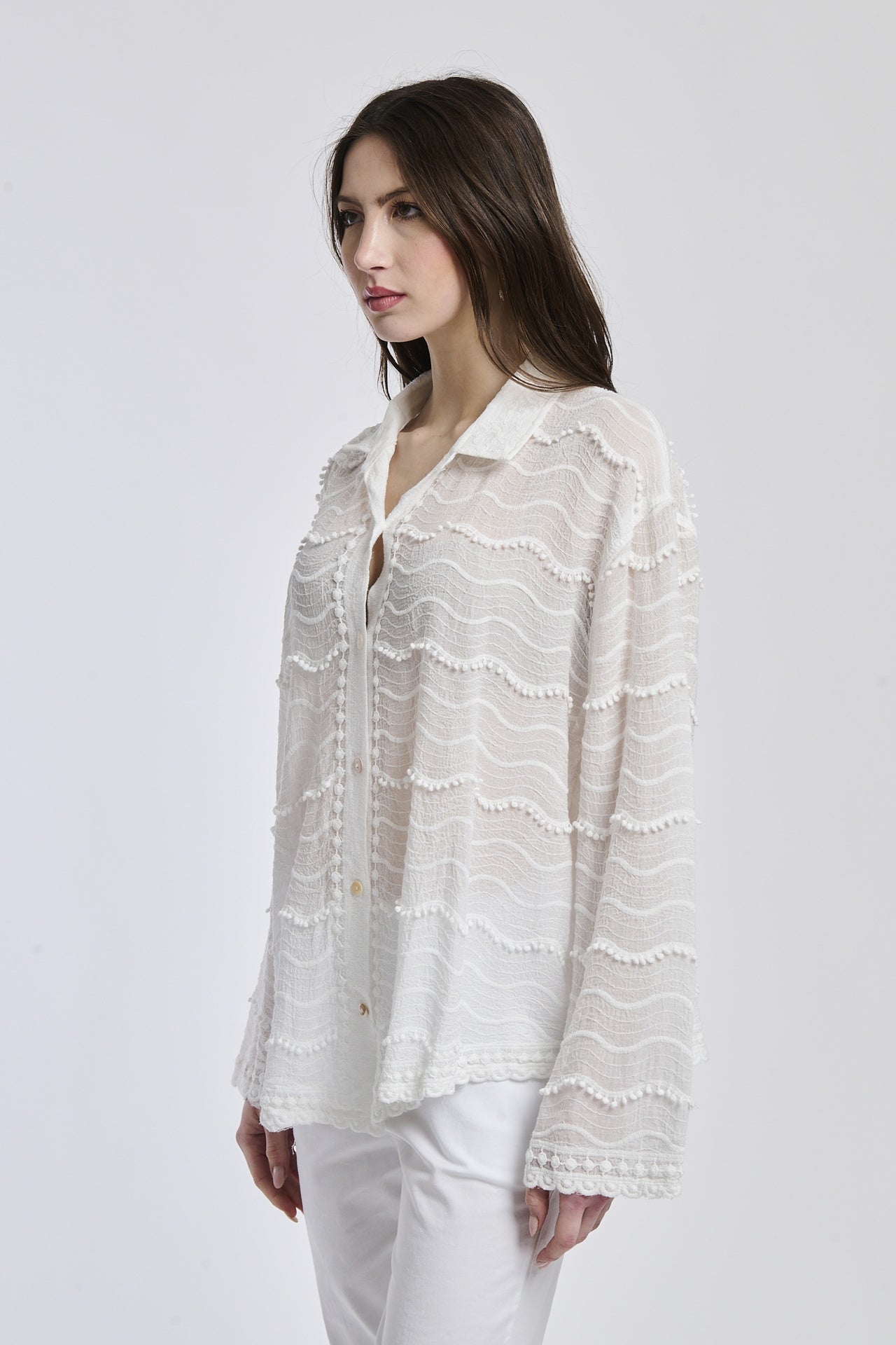 Outfit casual: camicia traslucida bianco e pantaloni bianchi, donna con capelli lunghi e orecchini