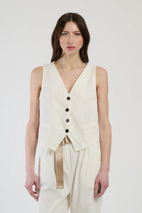Donna con completo bianco: gilet e pantaloni, luminosità e freschezza per un look impeccabile.