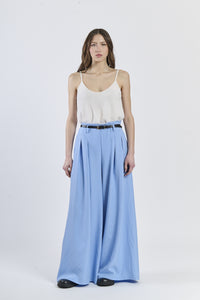 Look con top a bretelle sottili e pantaloni azzurri a gamba larga