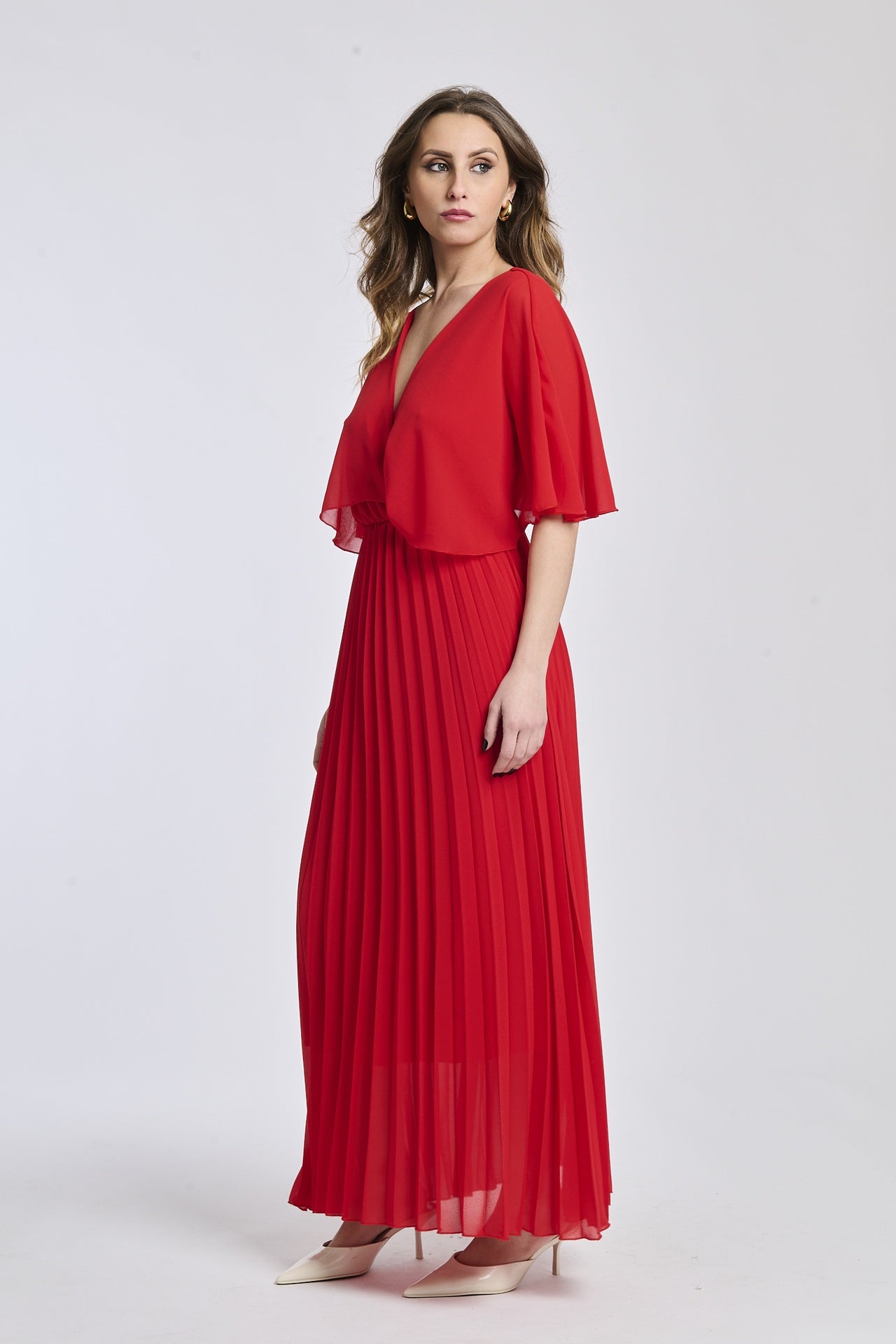 Vestito in rosso vivo con dettagli di falde e maniche, offrendo un look sorprendente e vibrante.