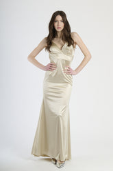  Donna con abito beige in raso, calore neutro e eleganza sobria.