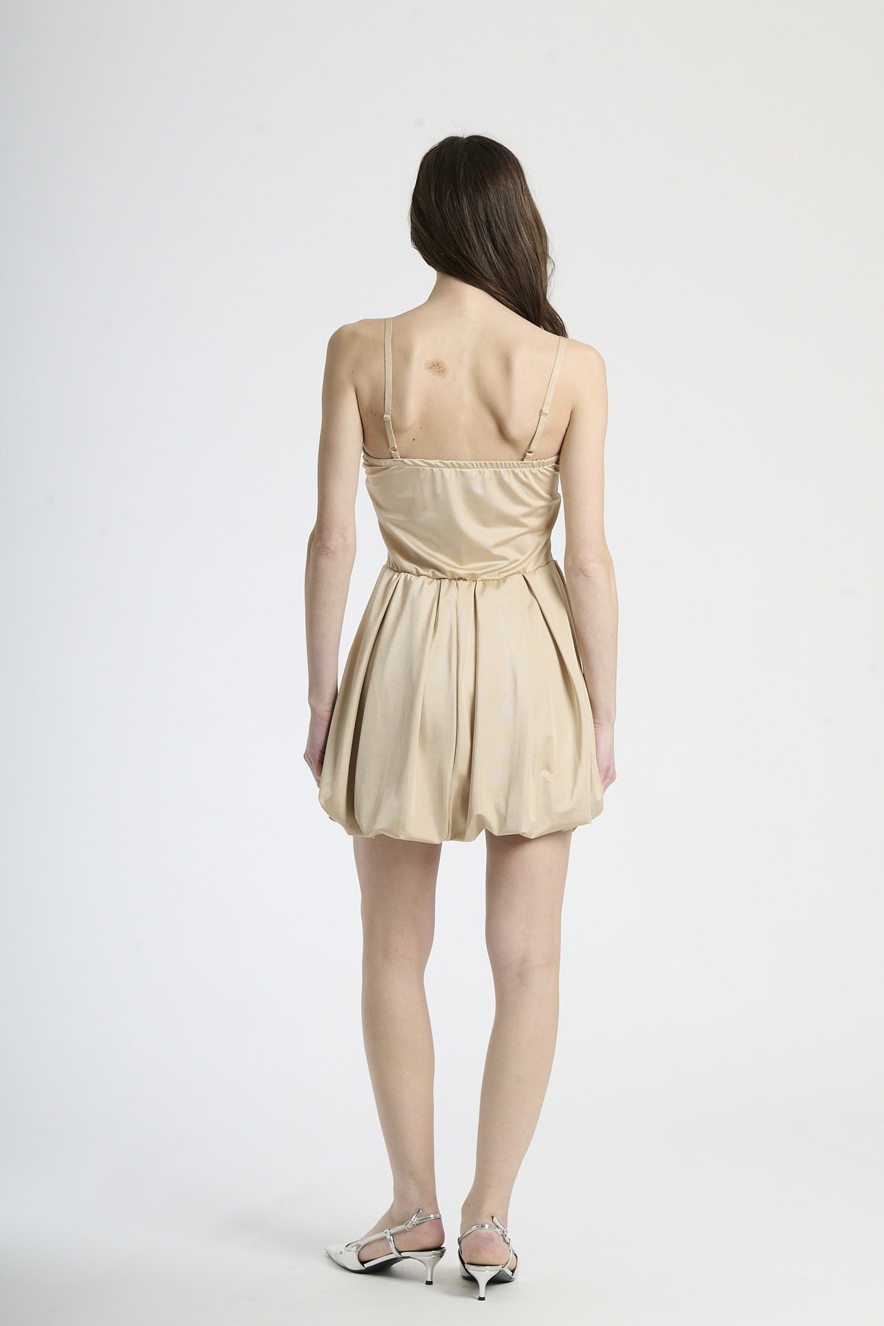 Vestito beige in tessuto soft, taglio corto con bretelle sottili, adatto per giornate di sole.