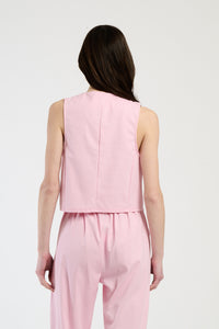 Completo rosa su una modella: gilet a bottoni e pantaloni,