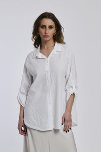 Camicia oversize bianca a righe, colletto a V sfiorato, bottoni frontali e maniche arrotolate, idea per outfit estivi.
