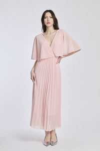 Un vestito in rosa tenero, con il taglio crociato sul busto e le maniche a mantello del modello originale, che dà un senso di dolcezza e femminilità.