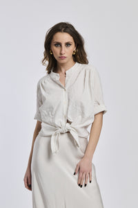 Camicia a righe beige e bianche da donna, nodo sul basso, abbinata a gonna beige, look 