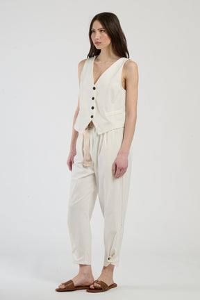 Donna con completo bianco: gilet e pantaloni, luminosità e freschezza