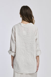 Camicia oversize a righe beige, colletto classico, bottoni e maniche arrotolate, stile minimalista.