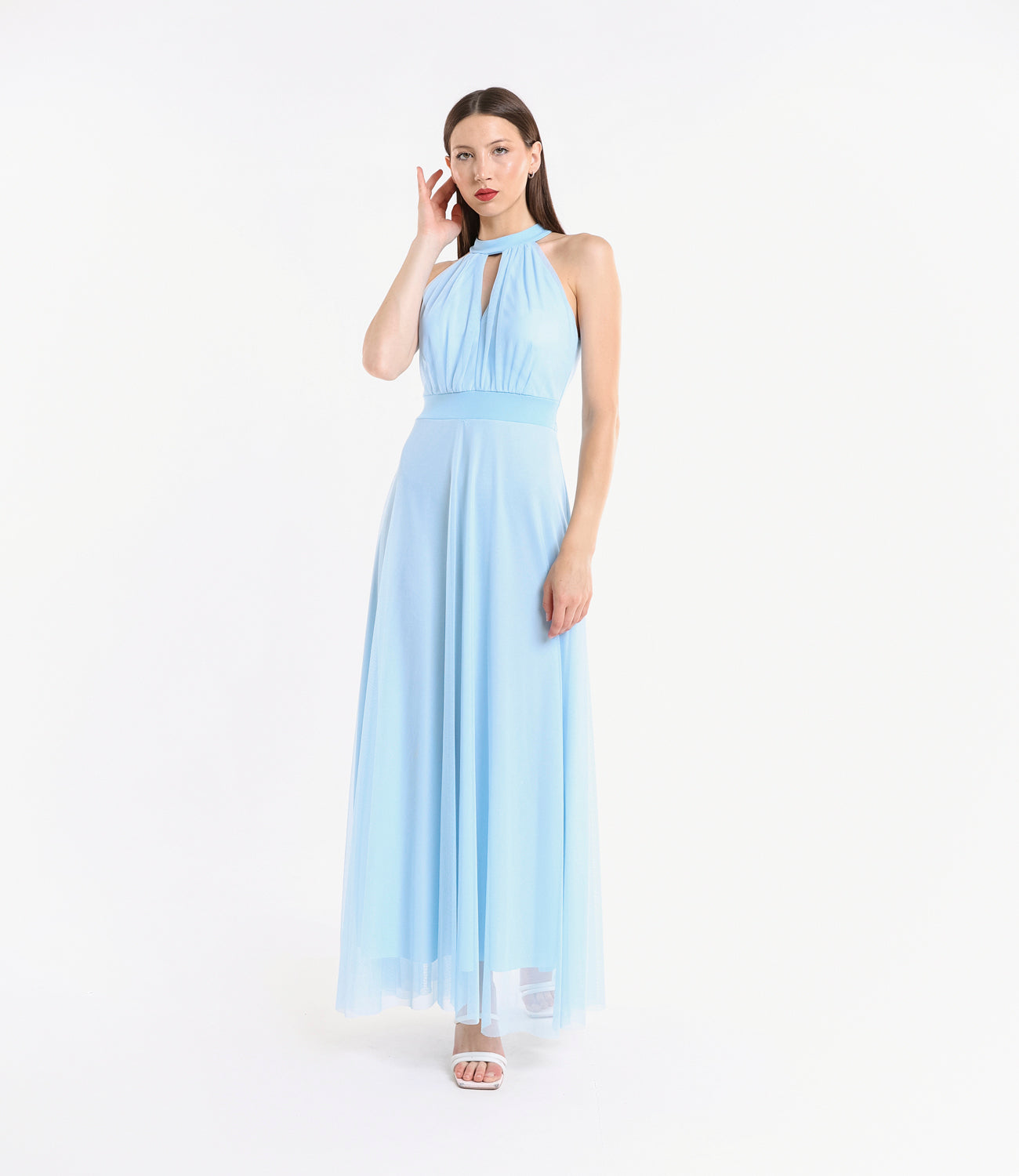 Abito azzurro trasparente in tulle, colletto alto, vicino a pianta verde artificiale