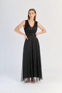 Abito nero da festa, silhouette avvolgente e colletto a V, fascinazione oscura.